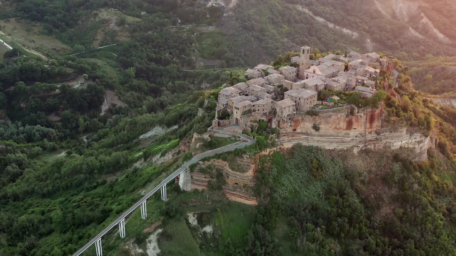 Civita di Bagnoregio on its tufa ridge, reached by a long footbridge, with the valley below.