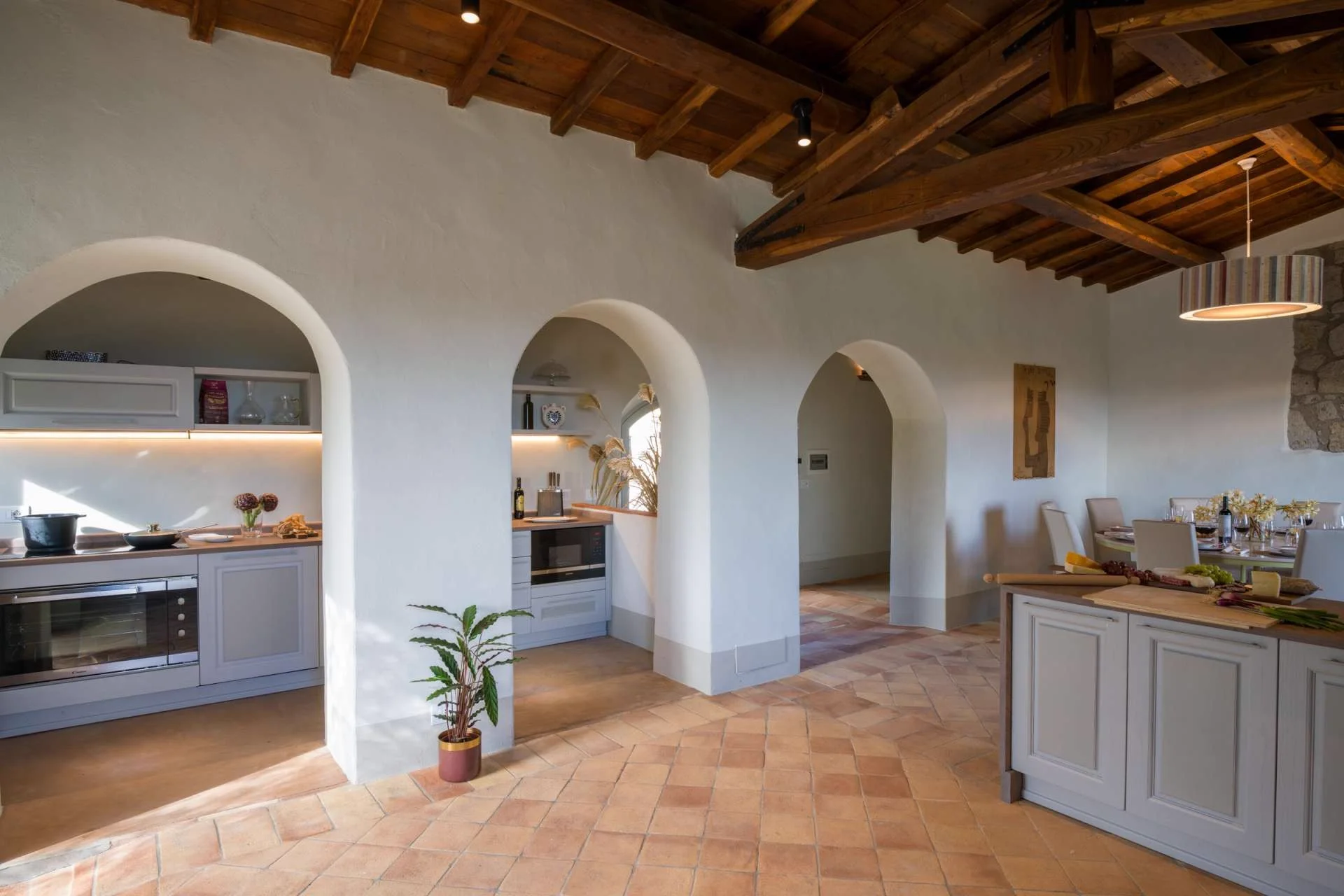 The villa kitchen with a wooden worktop, pans and utensils in reach.