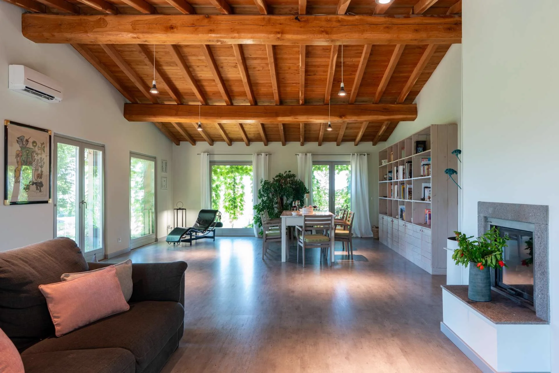 The living and dining room at Elaios, with a long wooden table and beamed ceiling.